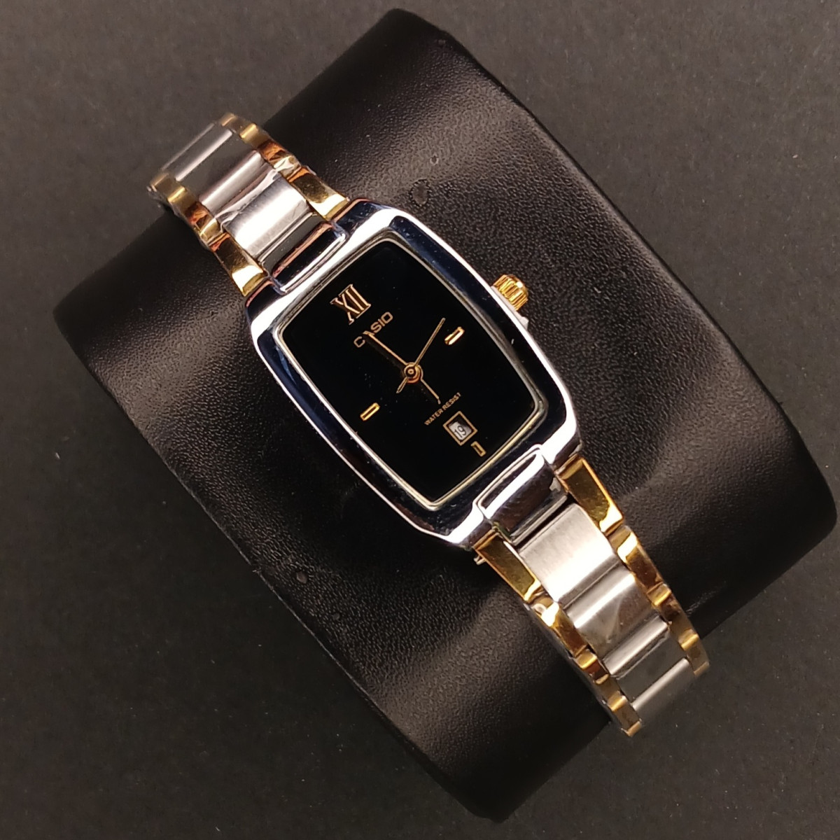 کاسیو مستطیل کد (6884) قاب نقره ای صفحه مشکی بند طلایی نقره ای